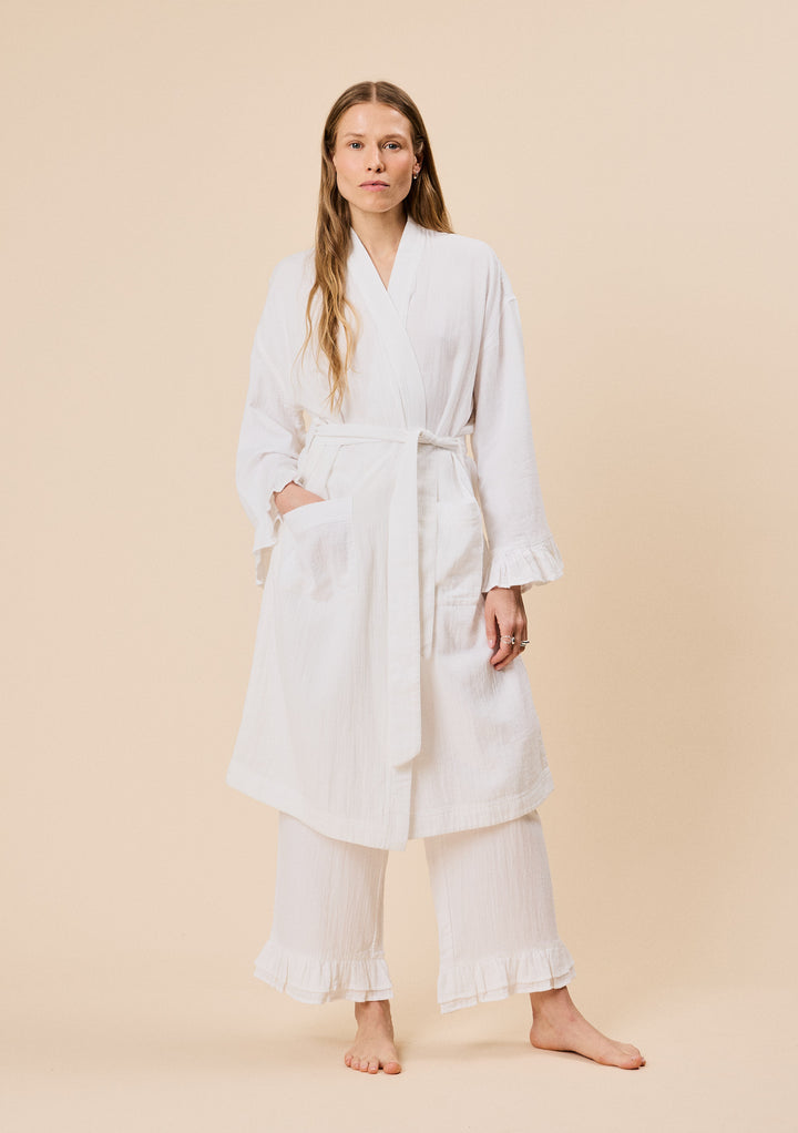Woman wearing TBCo Cotton Robe in White Ruffle with breathable natural and recycled fibres, Certified B-Corp, Women-Founded, designed to make an impact