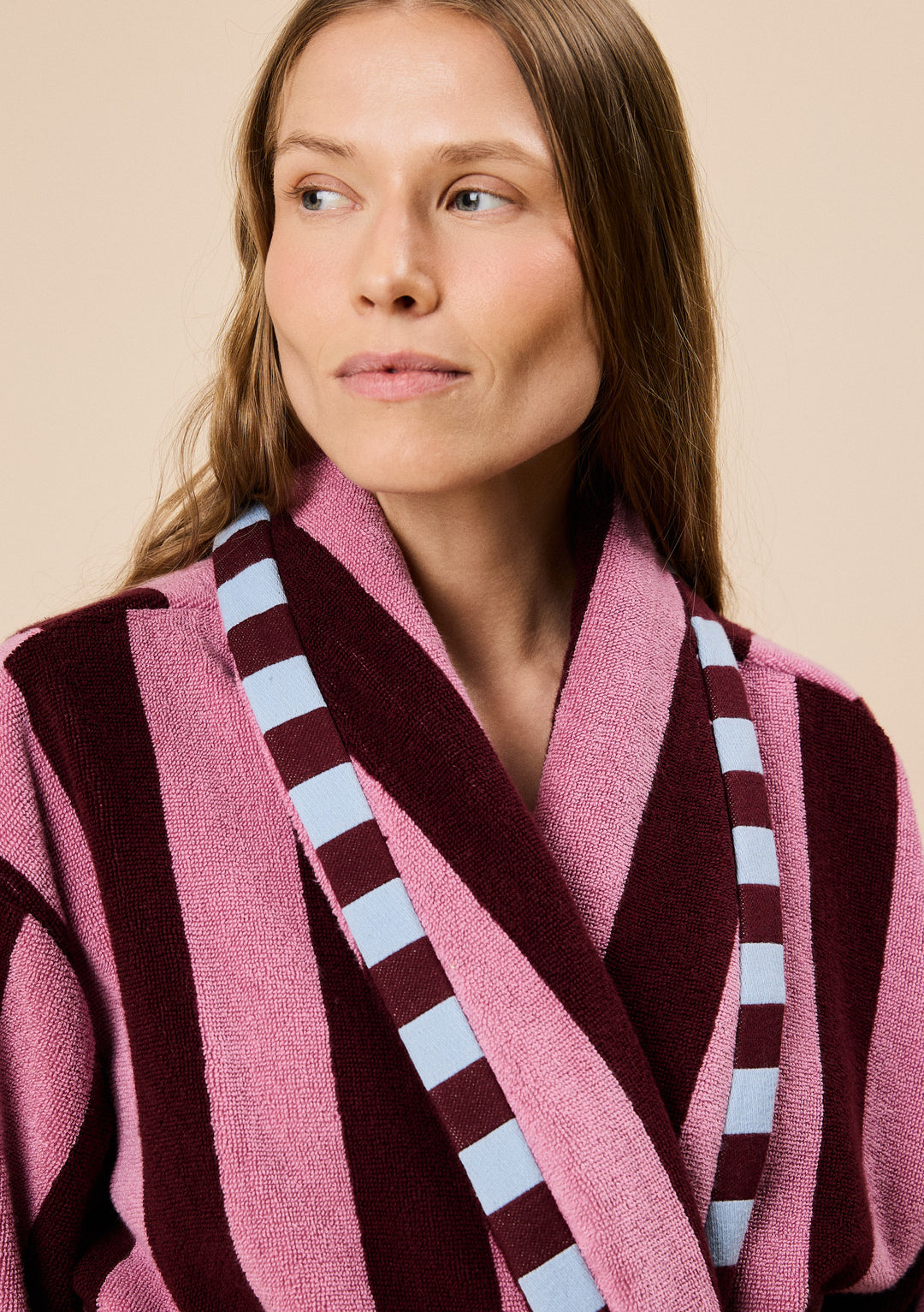 Close-up of model wearing TBCo Terry Cotton Bath Robe in Burgundy Stripe featuring wide vertical stripes and contrast trim