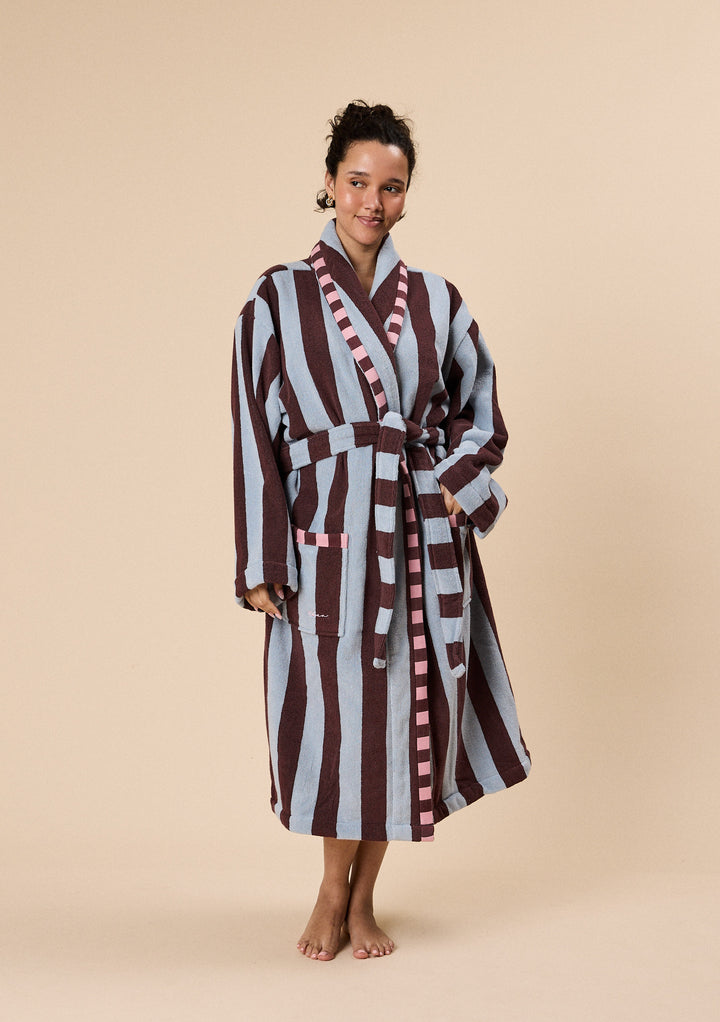 Woman wearing TBCo Terry Cotton Bath Robe in Blue Stripe with broad contrasting stripes and pink trim detail on pockets and collar