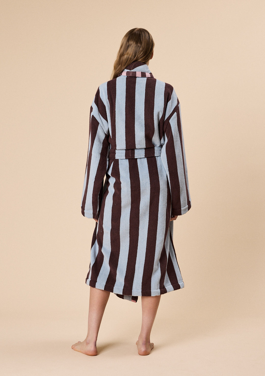 Woman wearing TBCo Terry Cotton Bath Robe in Blue Stripe with bold vertical stripes and a relaxed fit shown from behind
