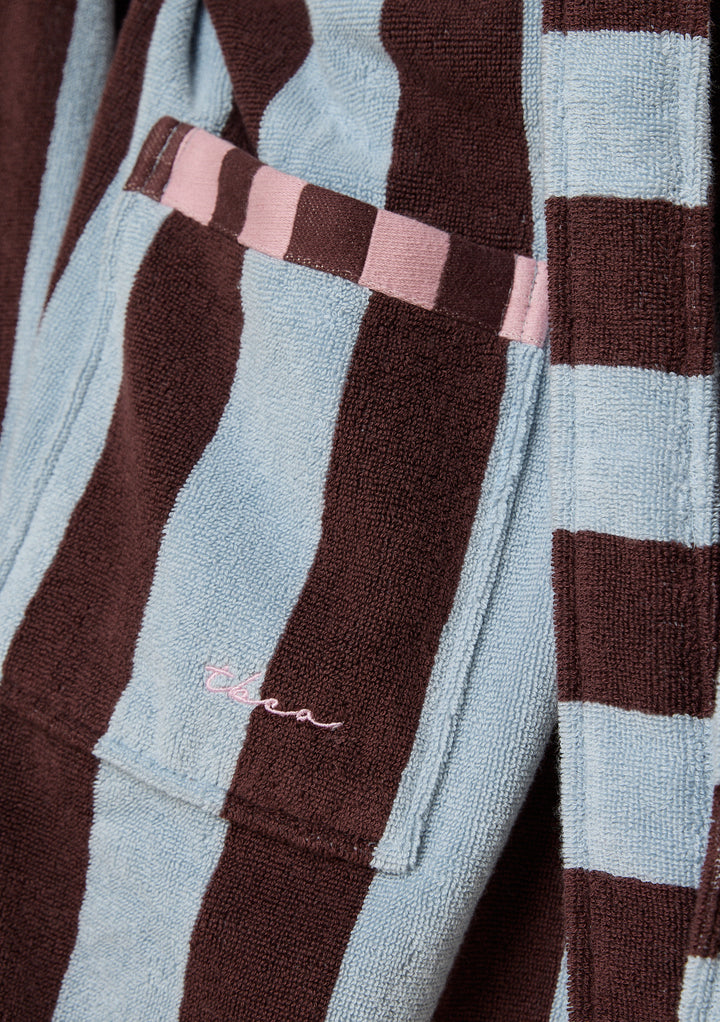 Close-up of TBCo Terry Cotton Bath Robe in Blue Stripe showing pocket with pink trim and embroidered TBCo logo detail