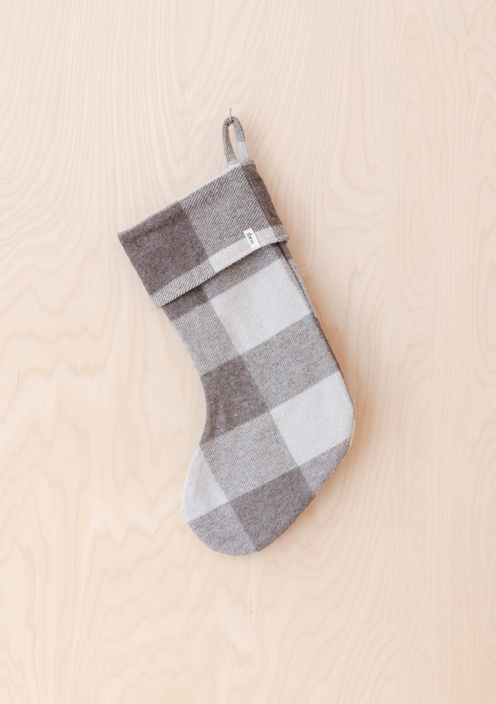Recycled Wool Christmas Stocking in Jacob Tartan by TBCo hanging on wooden background in neutral tones