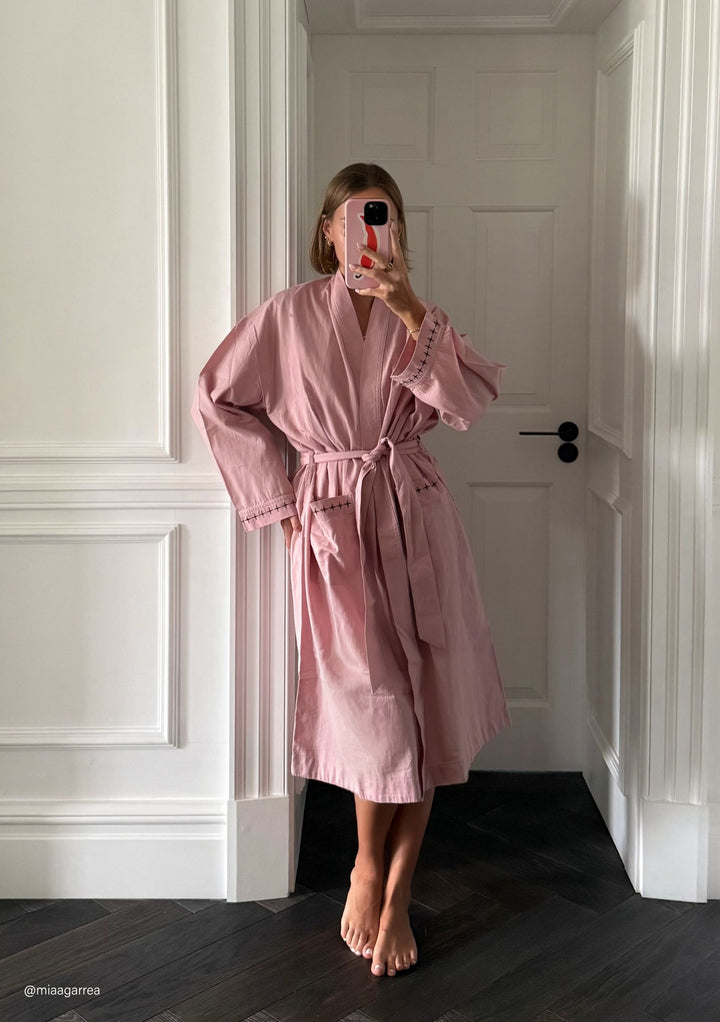 Woman taking mirror selfie wearing TBCo Cotton & Linen Robe in Pink with natural fibres, designed to make an impact